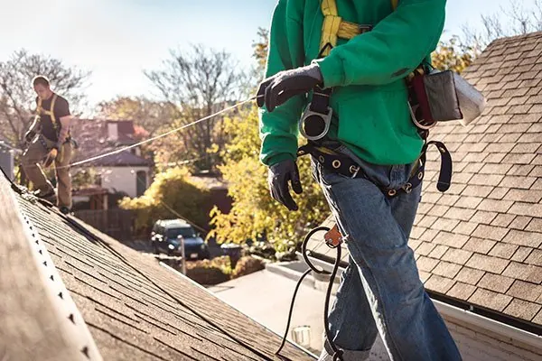 Roofing contractors working on a house roof